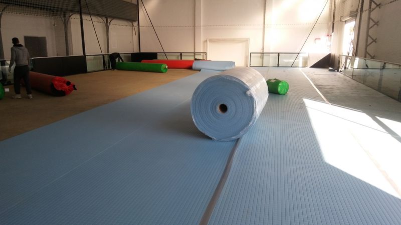 Pose du shock pad avant la pose du gazon synthétique spécial foot indoor